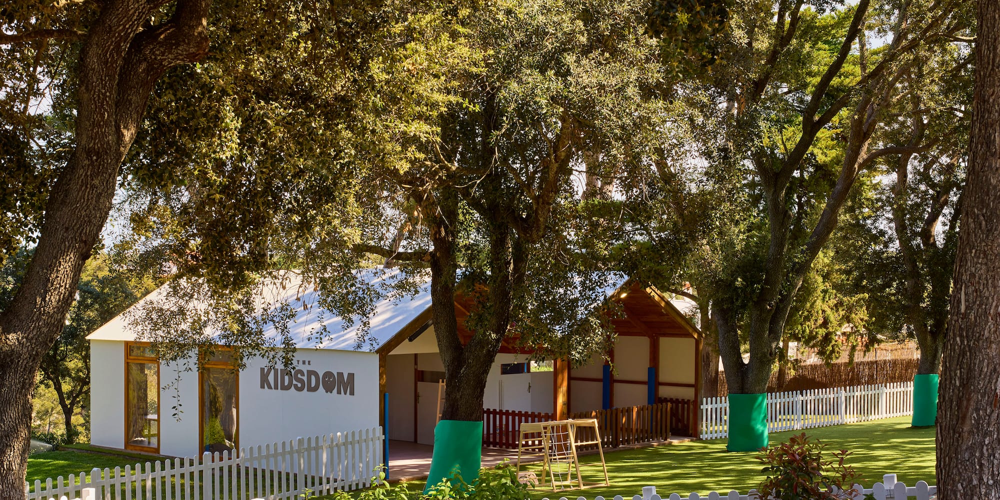 a white building with a white fence and trees