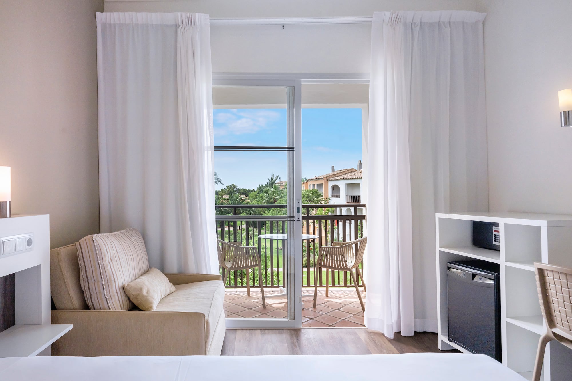 a room with a bed and a television and a balcony