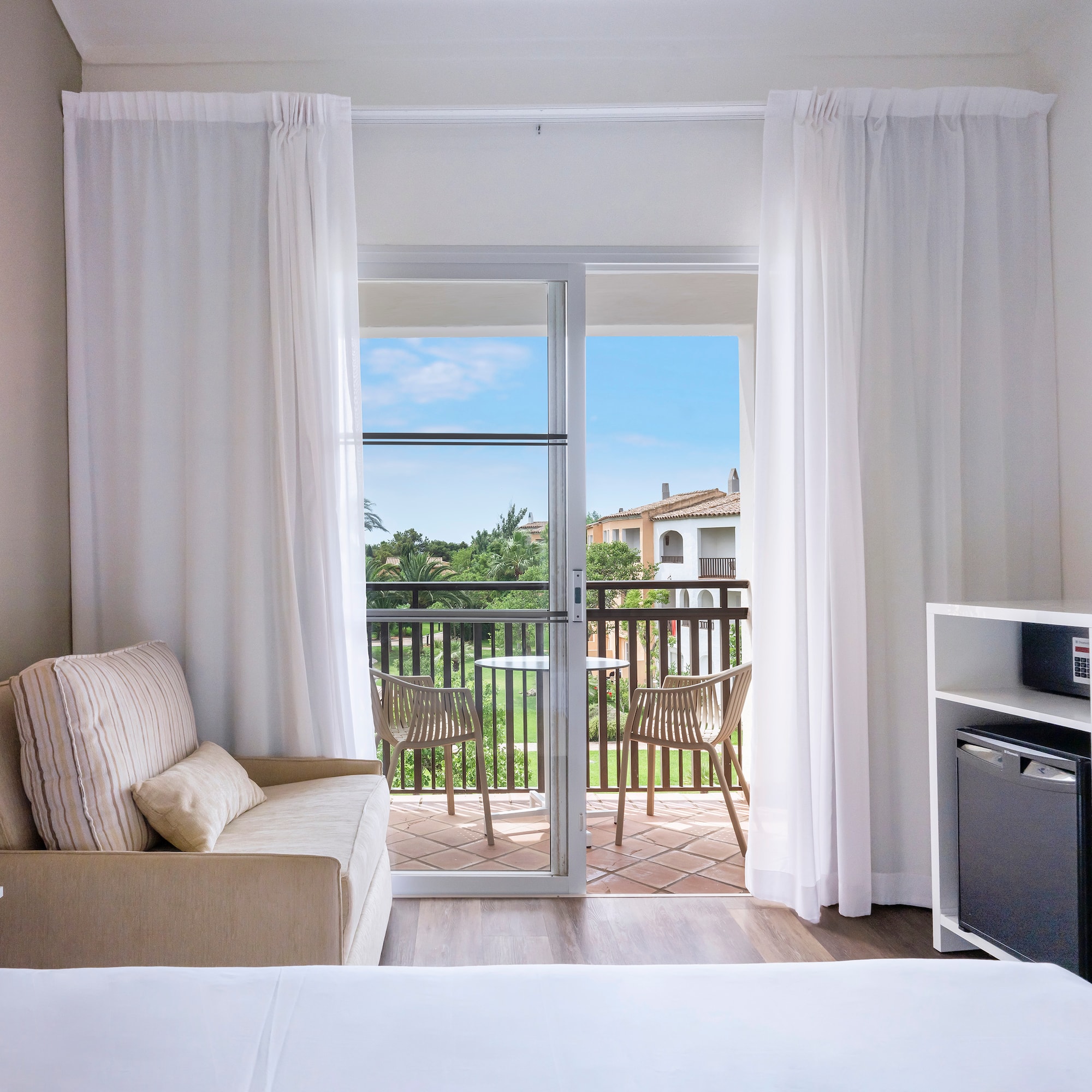 a room with a bed and a television and a balcony