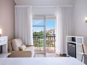 a room with a bed and a television and a balcony