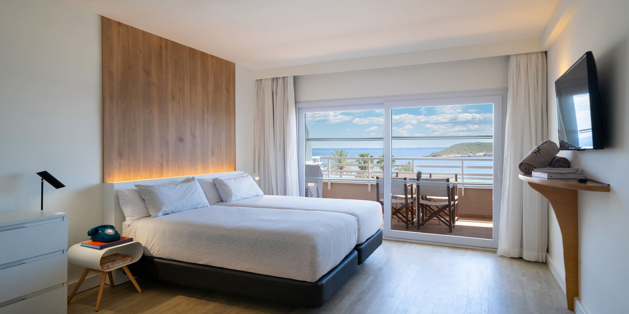 a bedroom with a large bed and a glass door