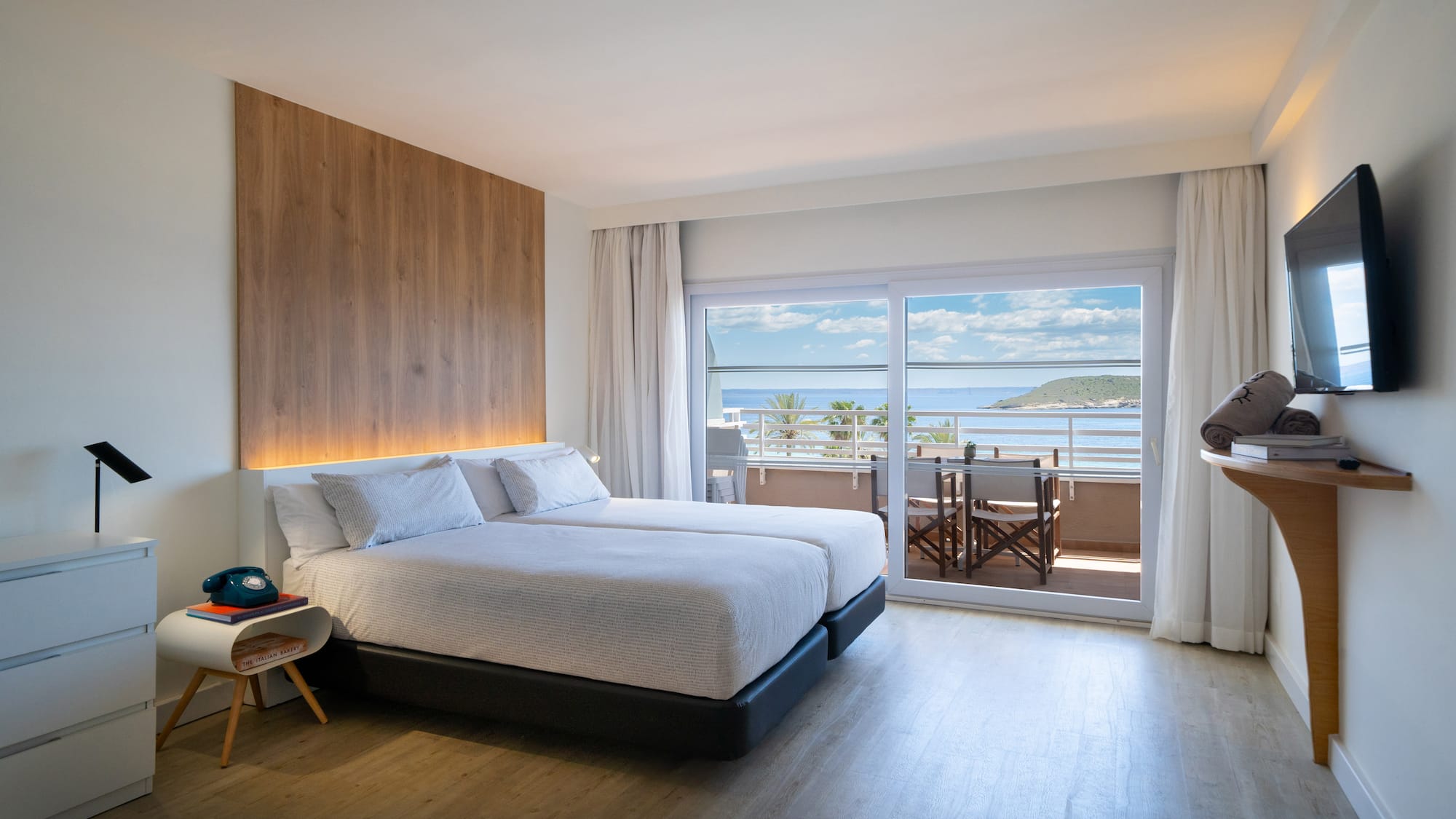 a bedroom with a large bed and a glass door