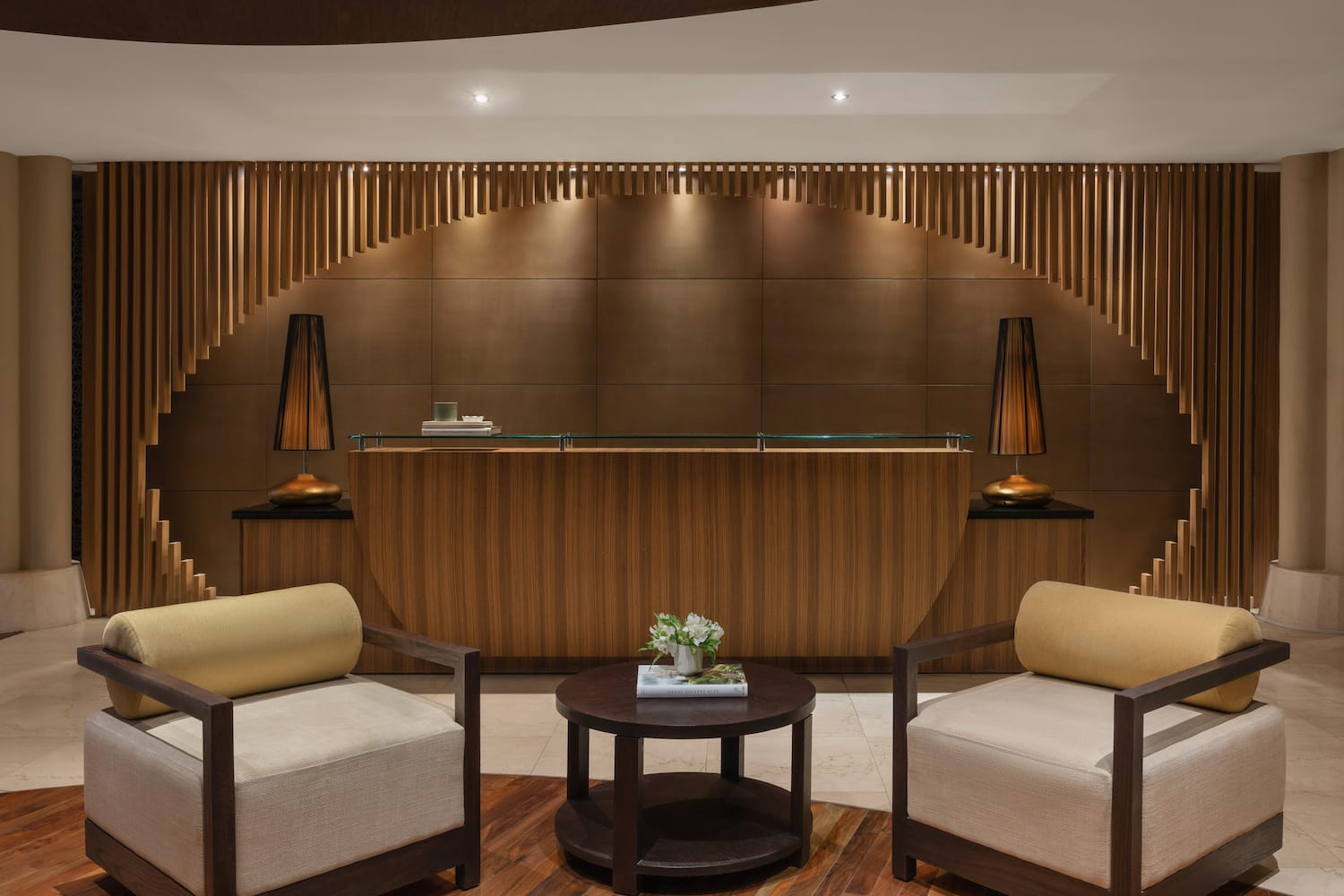 a reception desk with chairs and a table with flowers on top.