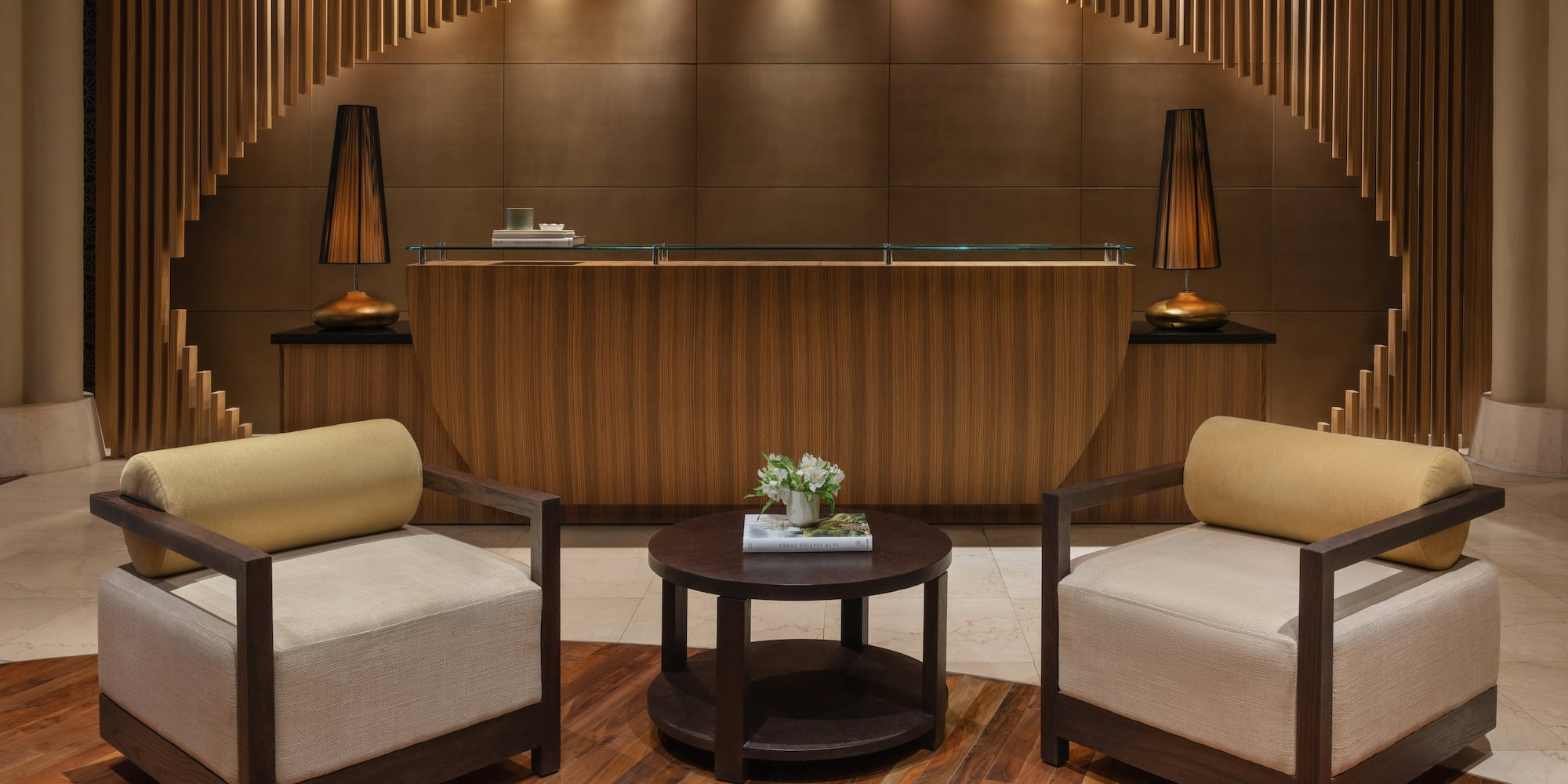 a reception desk with chairs and a table with flowers on top.