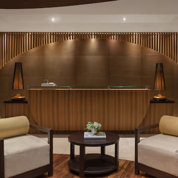 a reception desk with chairs and a table with flowers on top.