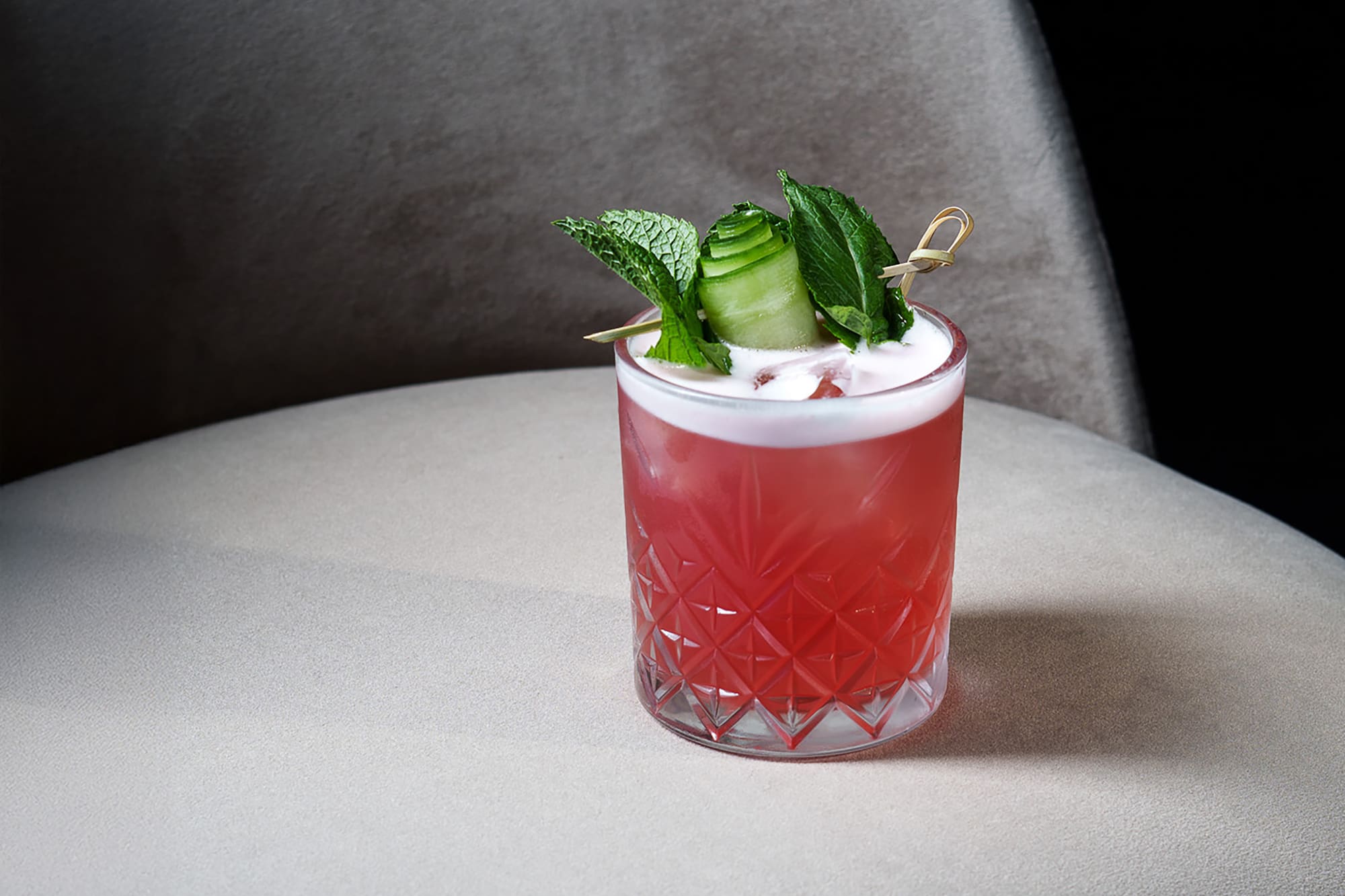 a glass with a drink and leaves on it