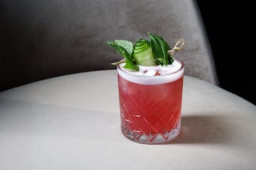 a glass with a drink and leaves on it