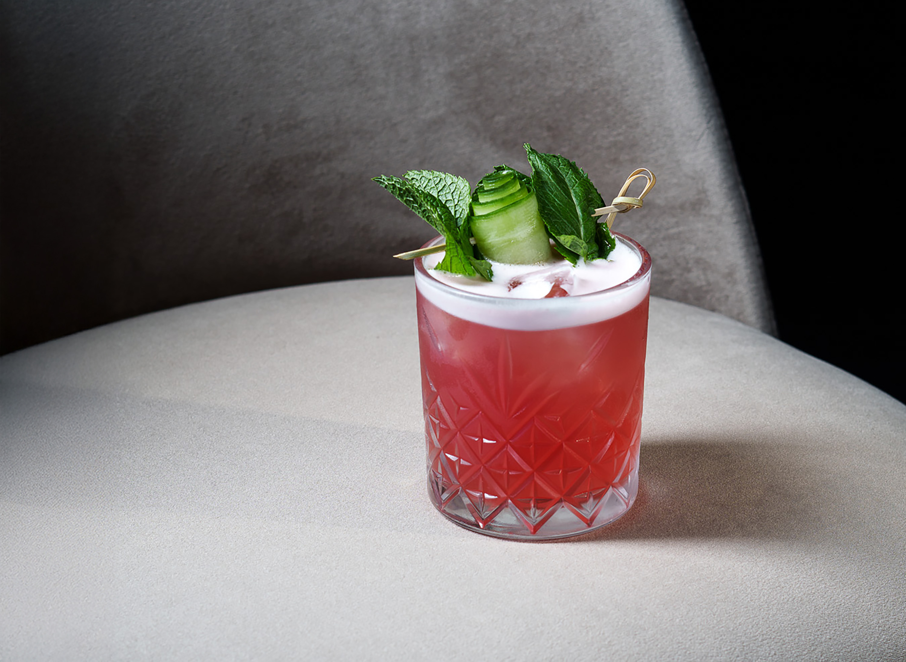 a glass with a drink and leaves on it