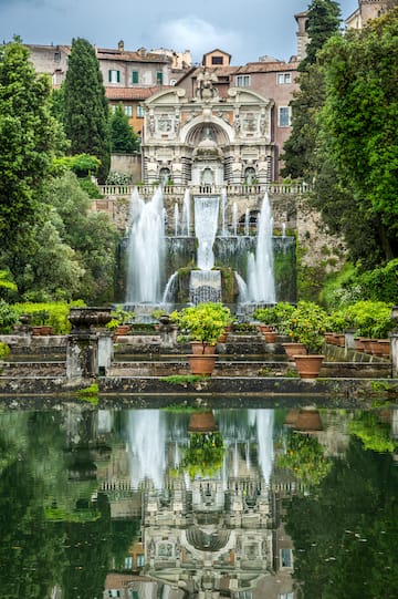 a water fountain with trees and Villa d'Este in the background