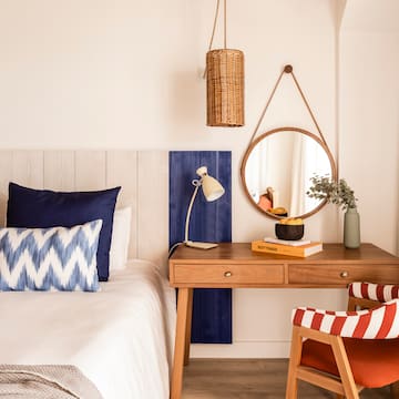 a bedroom with a desk and a mirror