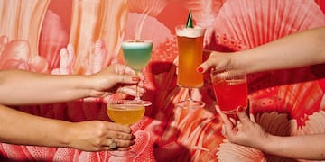 a group of hands holding glasses of drinks