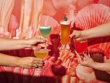 a group of hands holding glasses of drinks