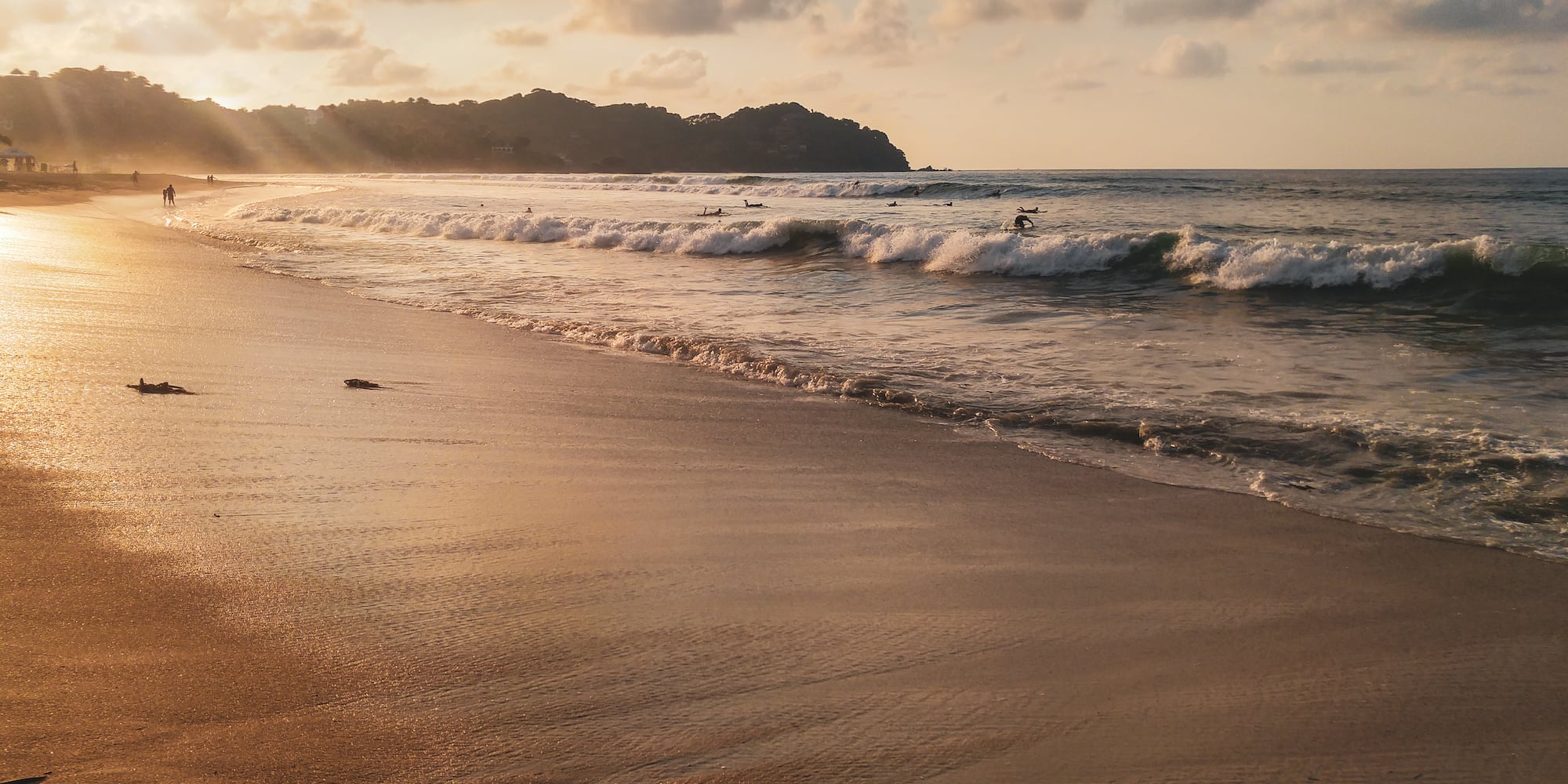 a beach with waves and people on it