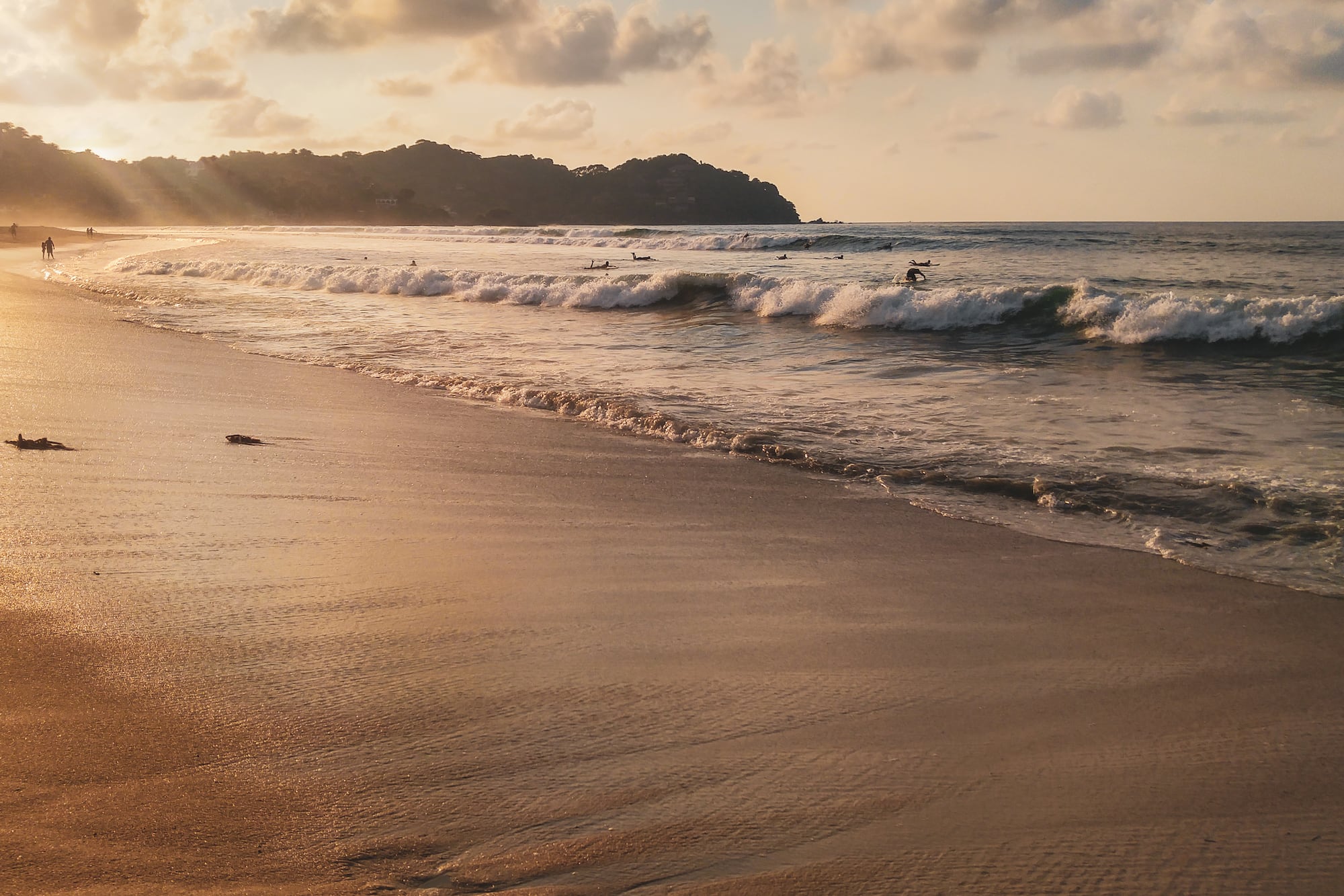 a beach with waves and people on it