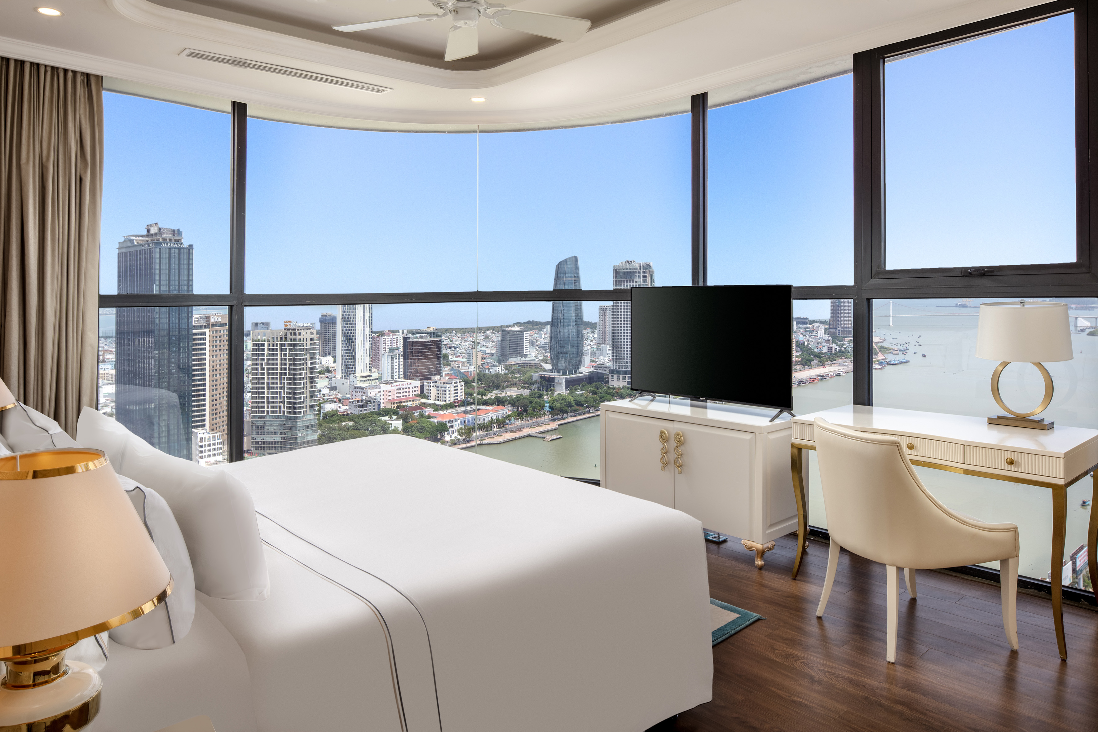 Luxury hotel room with panoramic city and ocean views, floor-to-ceiling window.