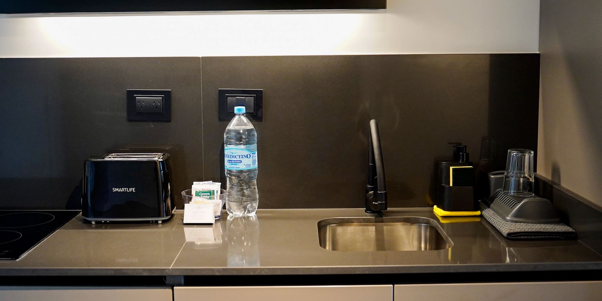 a kitchen counter with a sink and a bottle of water