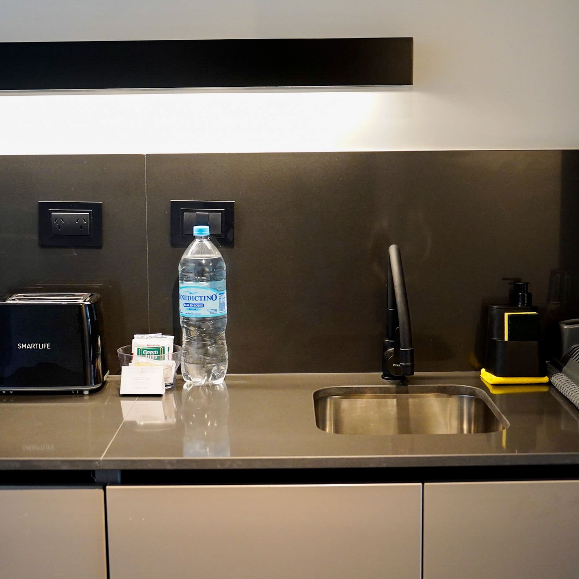 a kitchen counter with a sink and a bottle of water