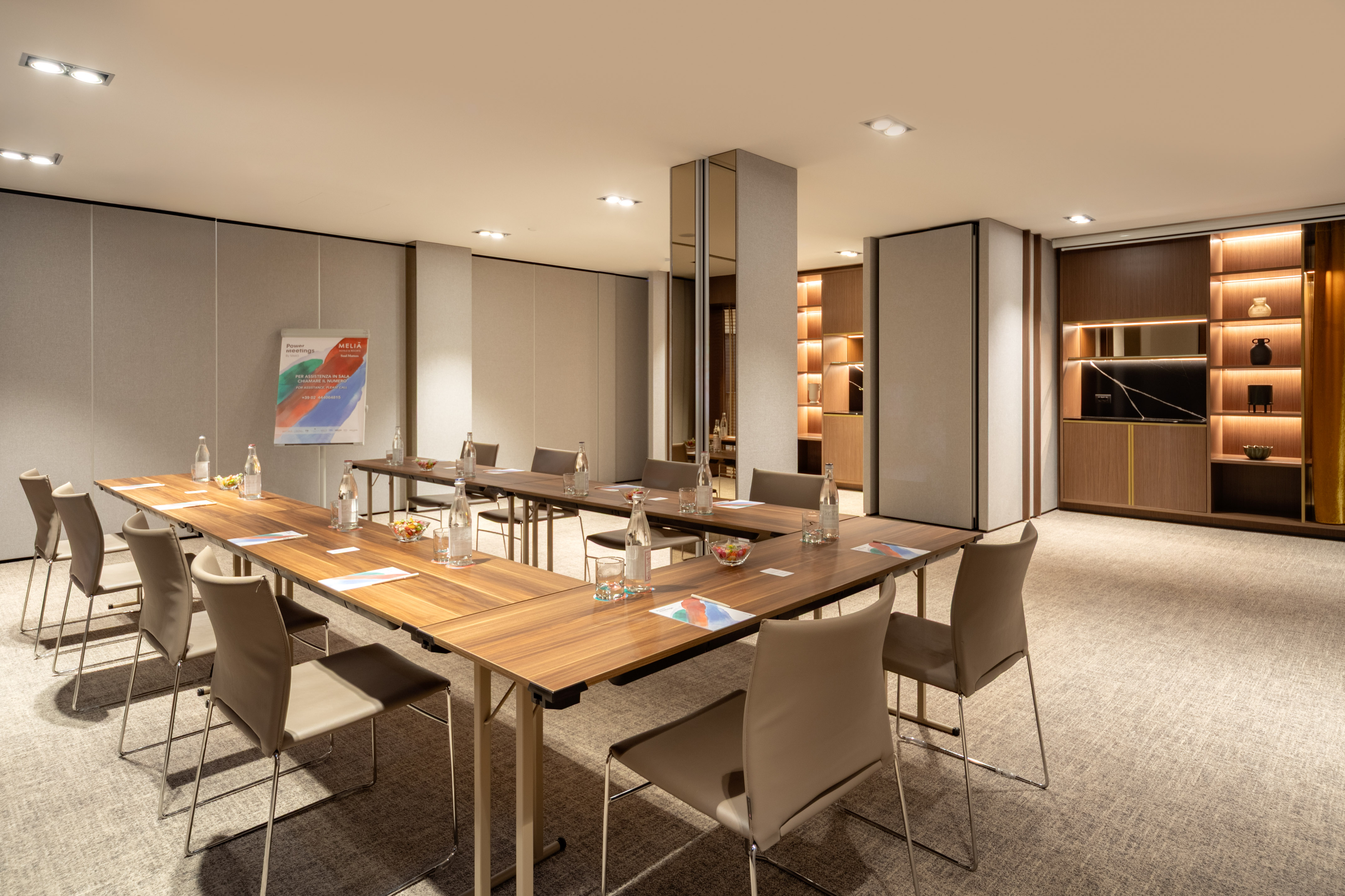 Melia hotel U-shaped meeting room setup with refreshments and a display.