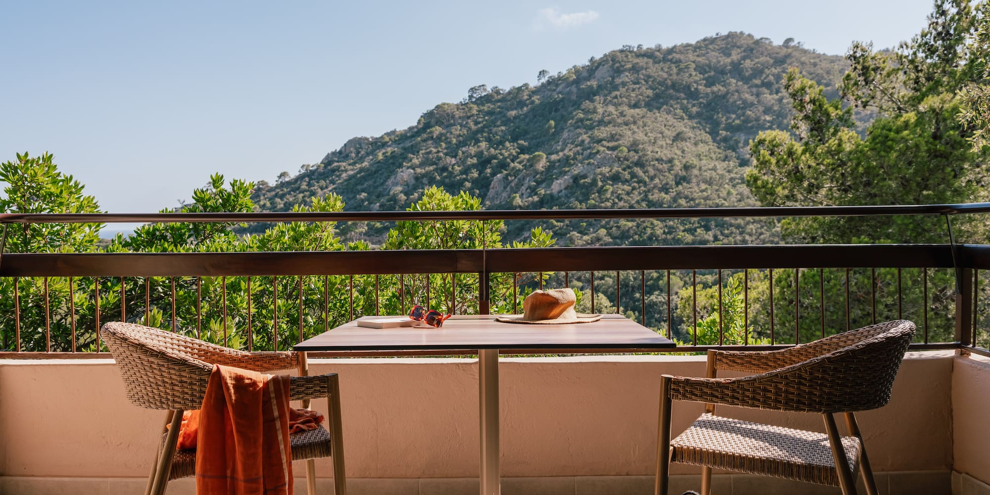 a table and chairs on a balcony overlooking a mountain