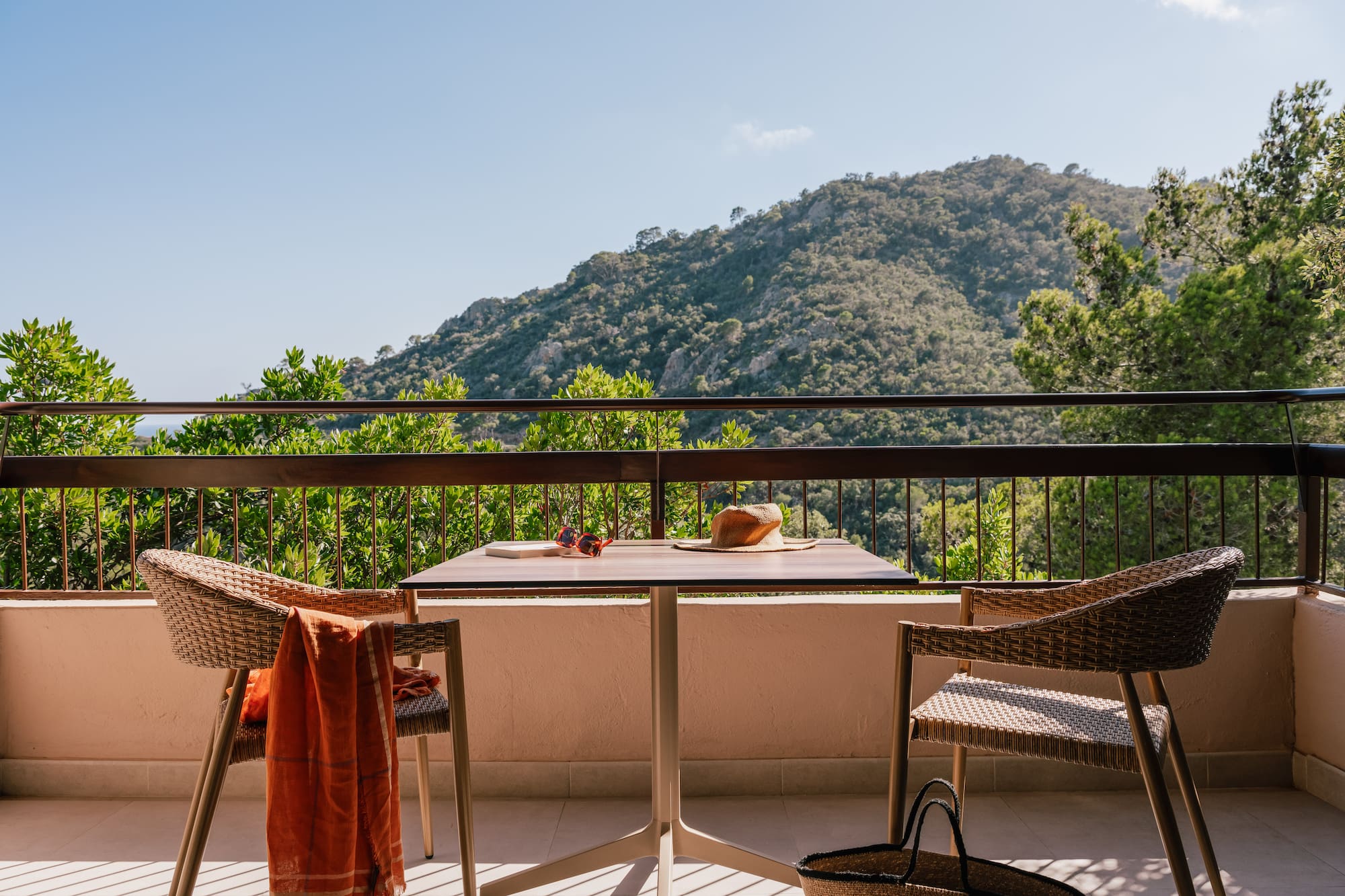 a table and chairs on a balcony overlooking a mountain
