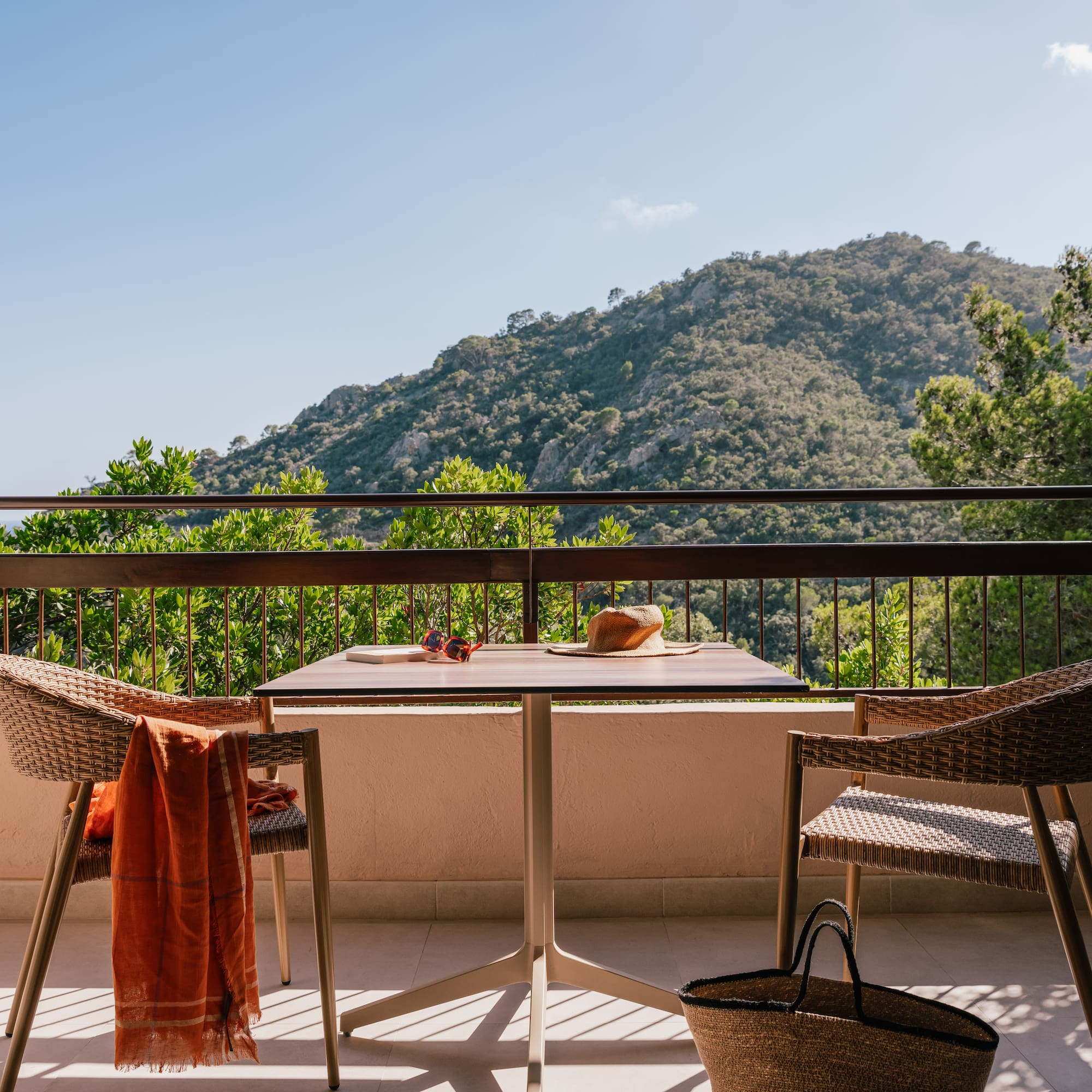 a table and chairs on a balcony overlooking a mountain