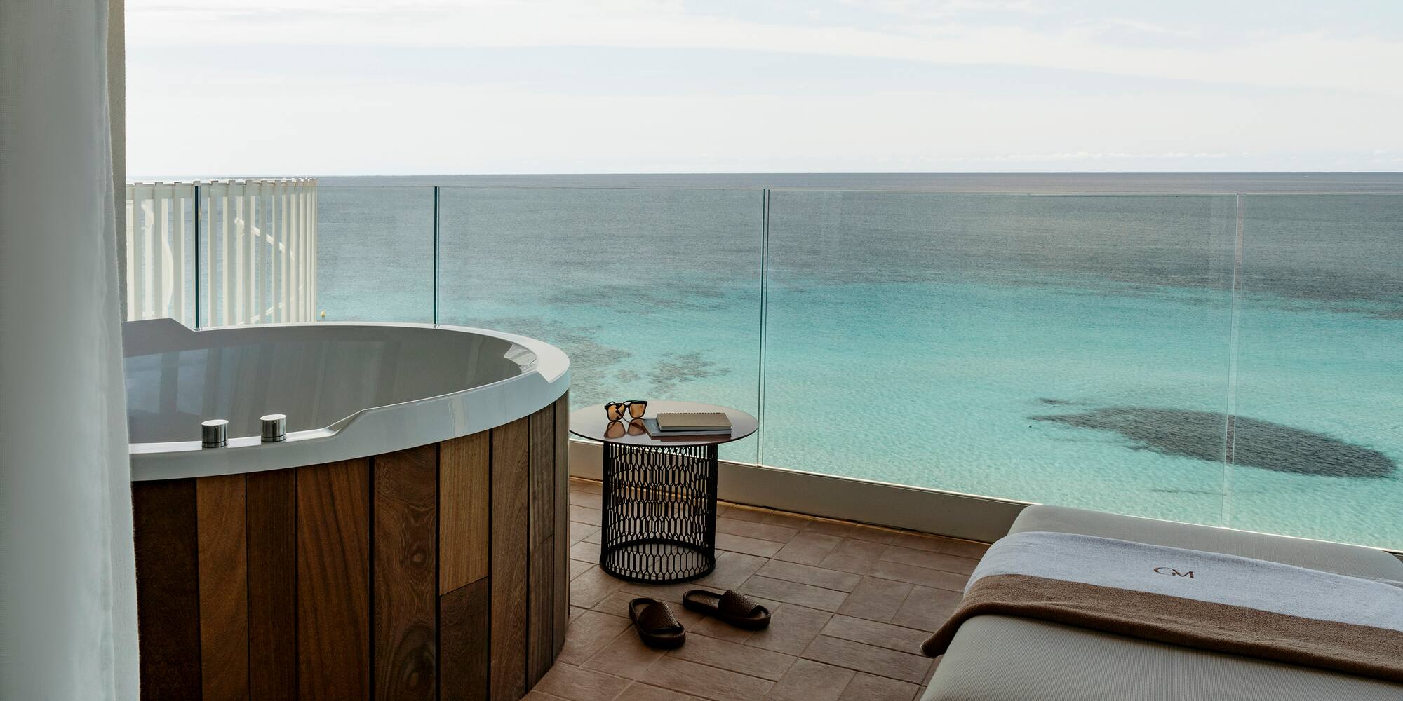 a room with a jacuzzi overlooking the ocean