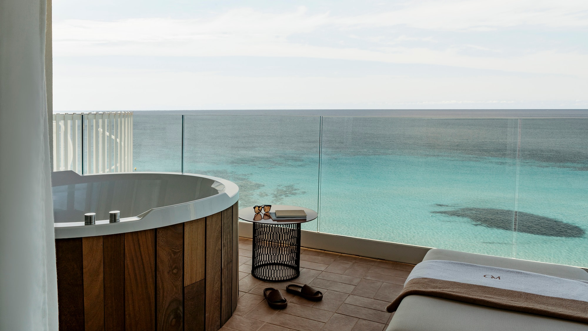 a room with a jacuzzi overlooking the ocean