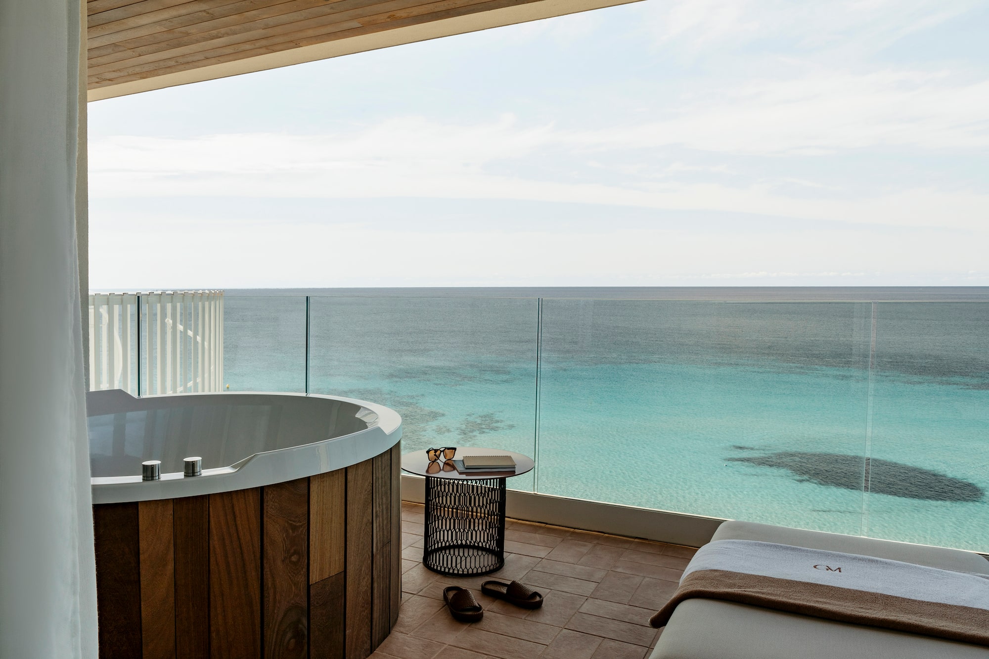 a room with a jacuzzi overlooking the ocean