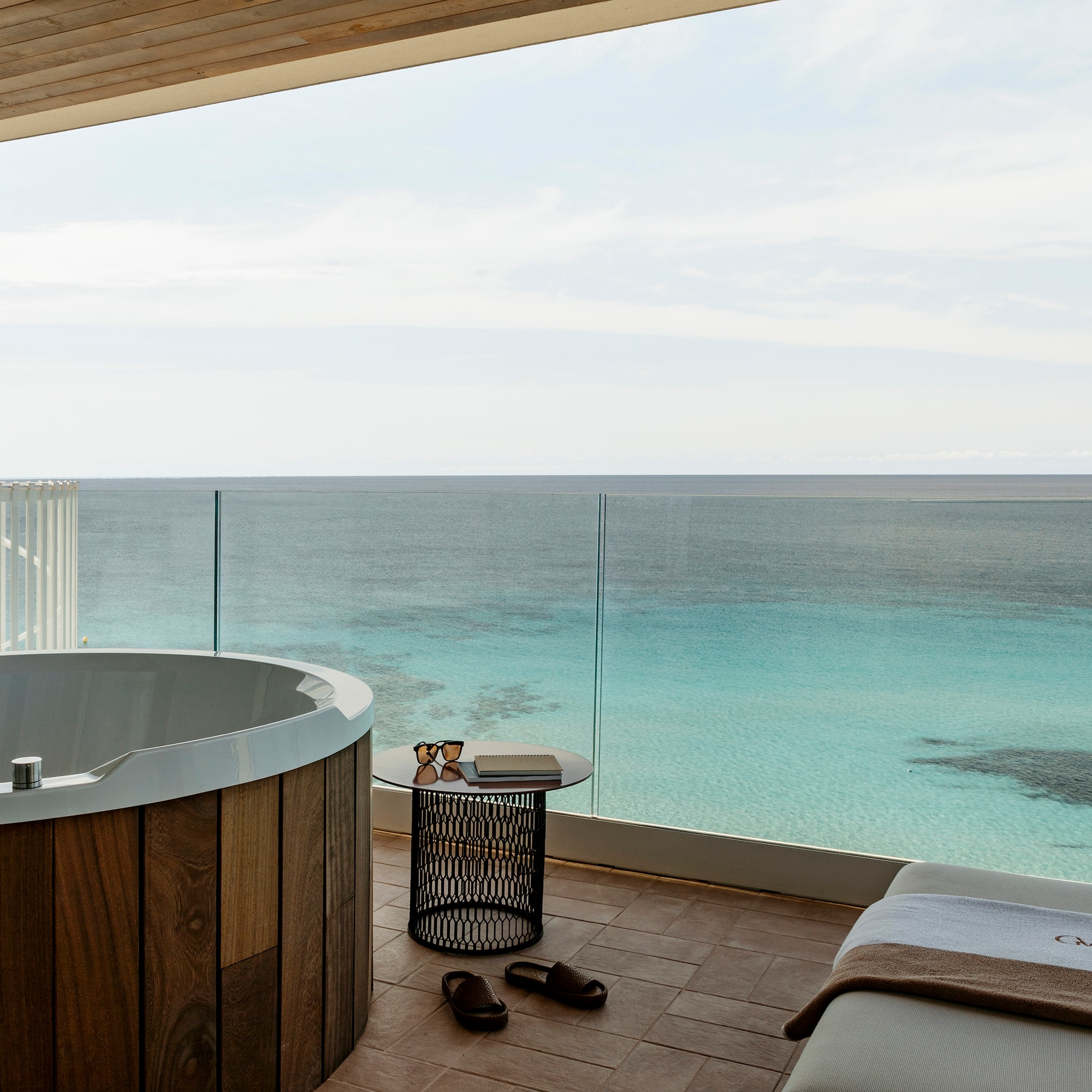 a room with a jacuzzi overlooking the ocean