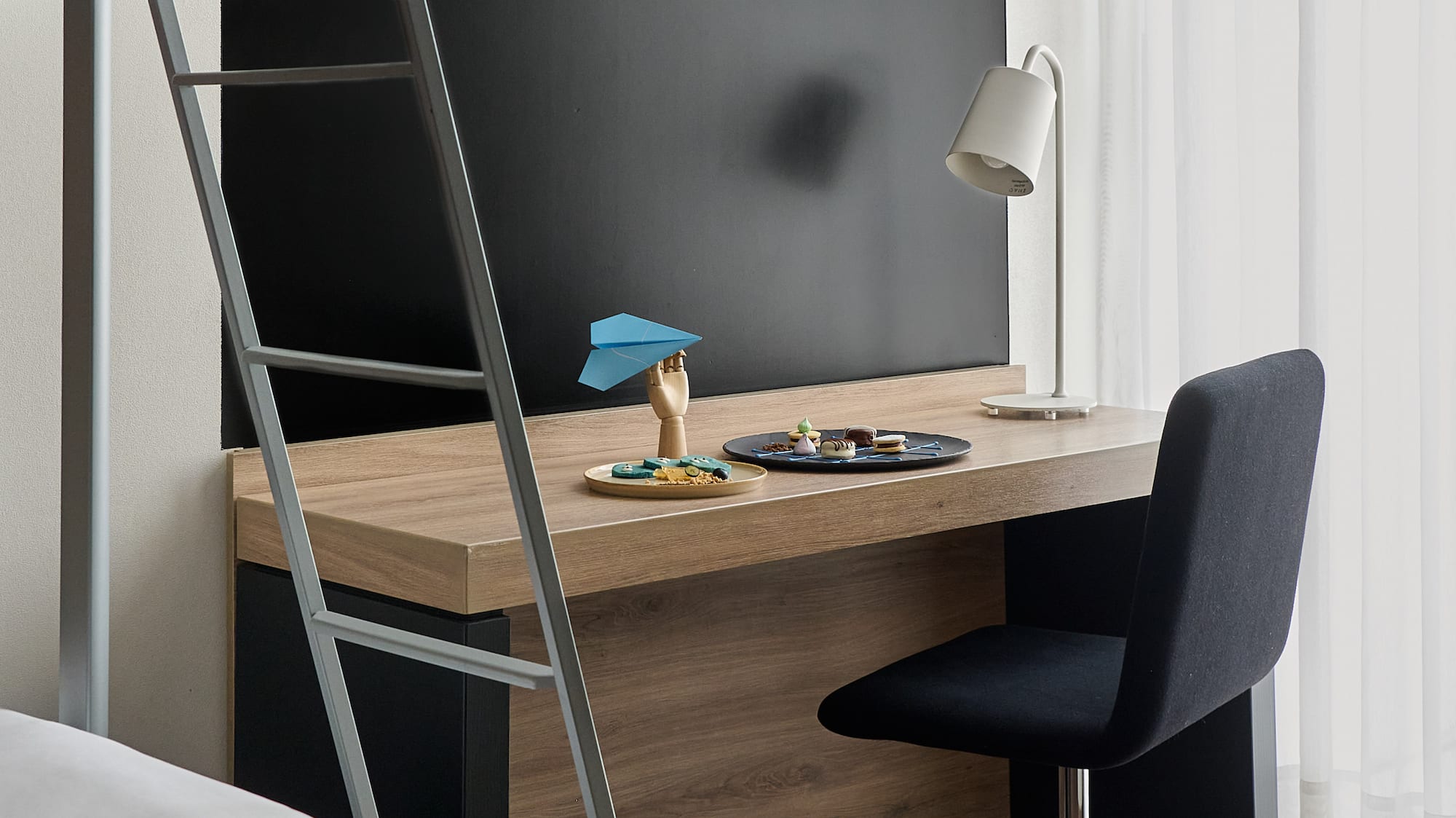 a desk with a ladder and a bed