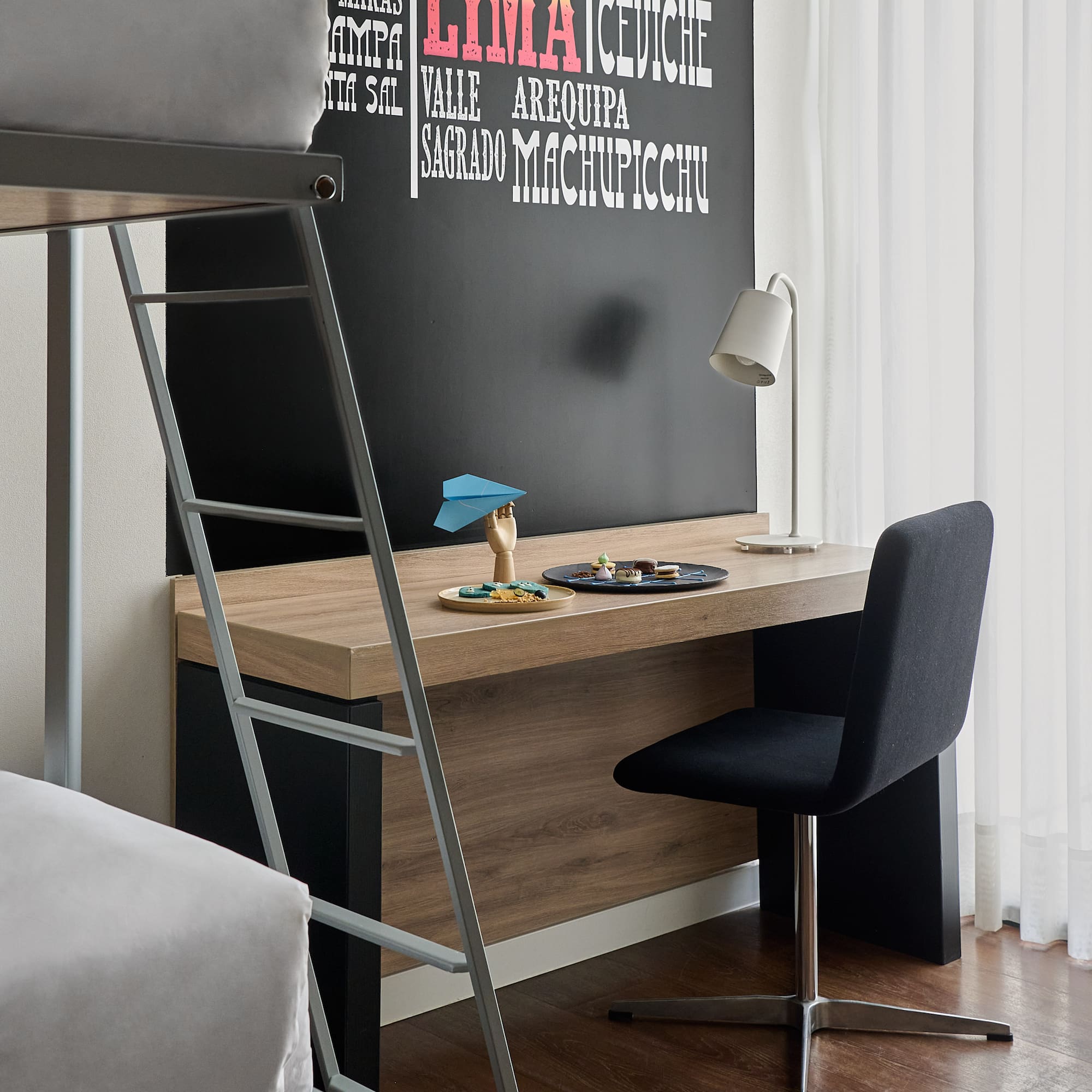 a desk with a ladder and a bed
