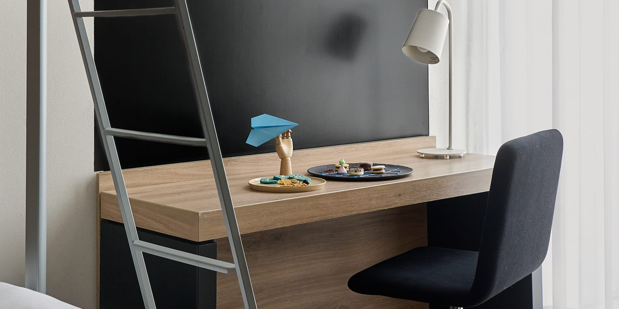 a desk with a ladder and a bed