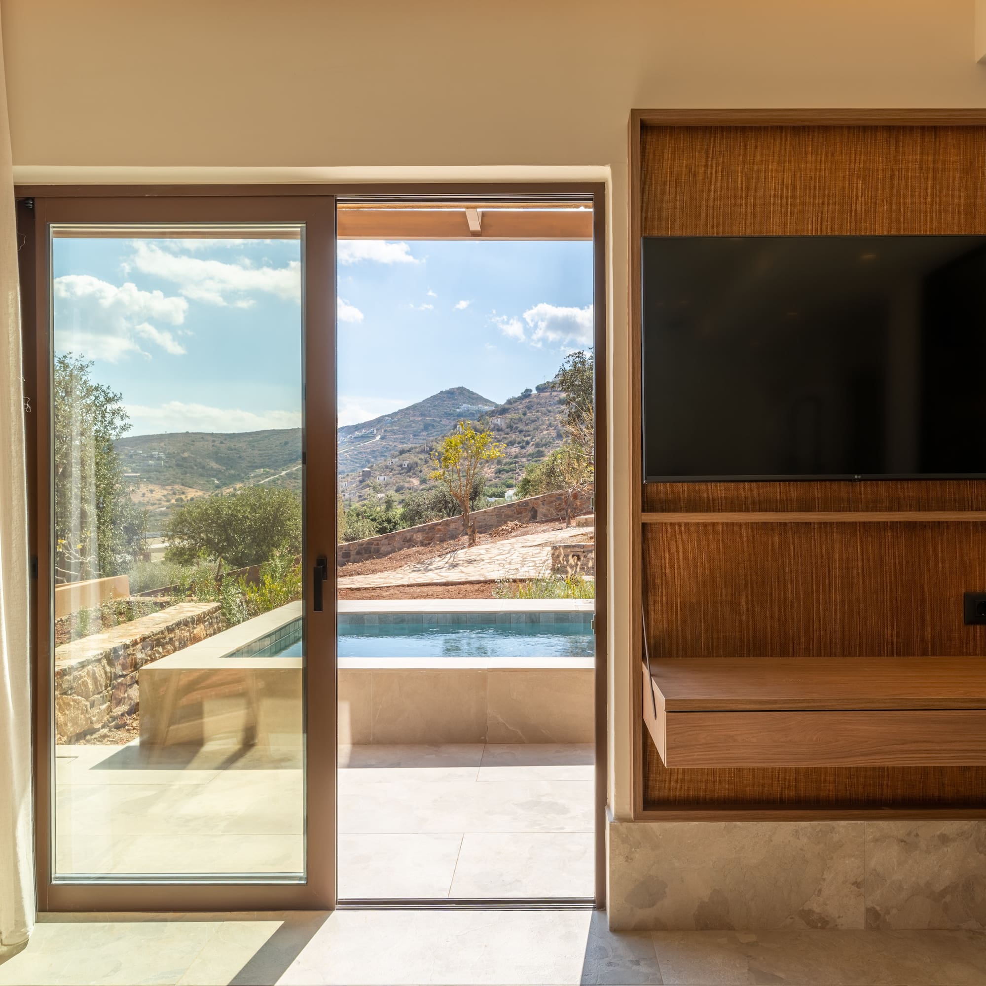 a room with a sliding glass door and a television