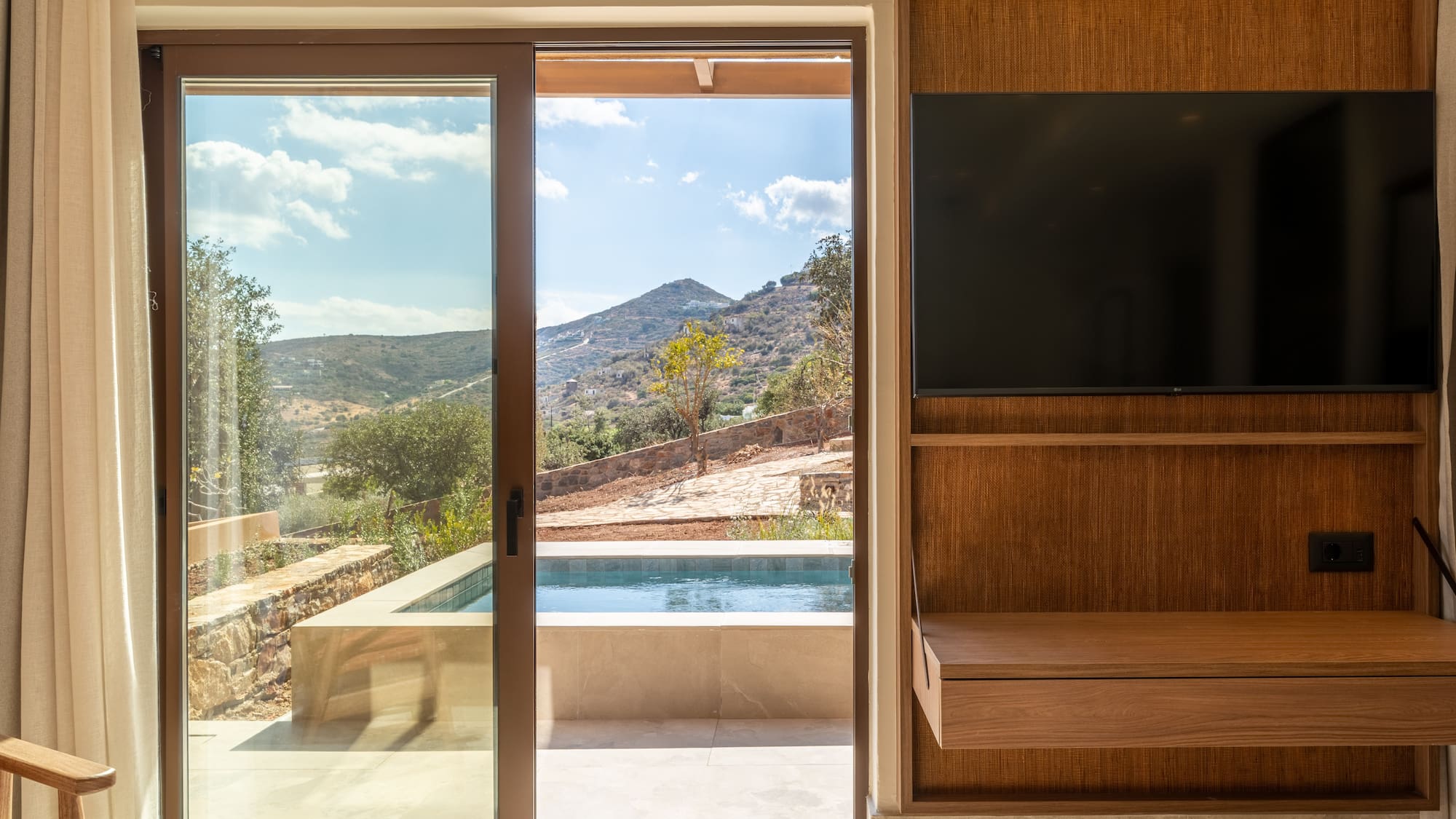 a room with a sliding glass door and a television