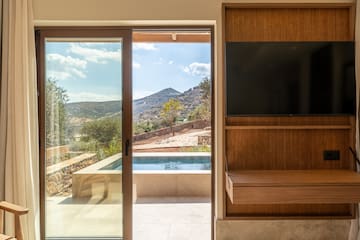 a room with a sliding glass door and a television