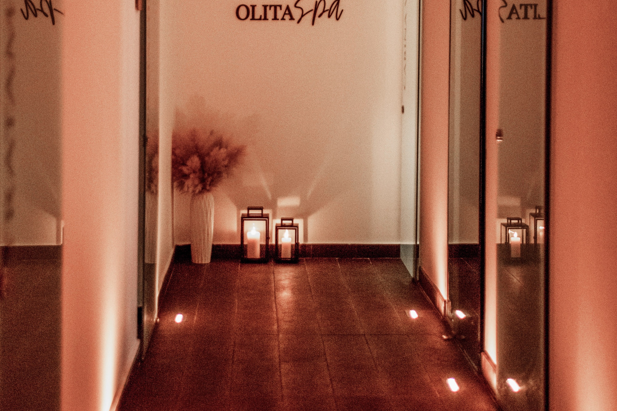 a hallway with lights and a vase on the side.