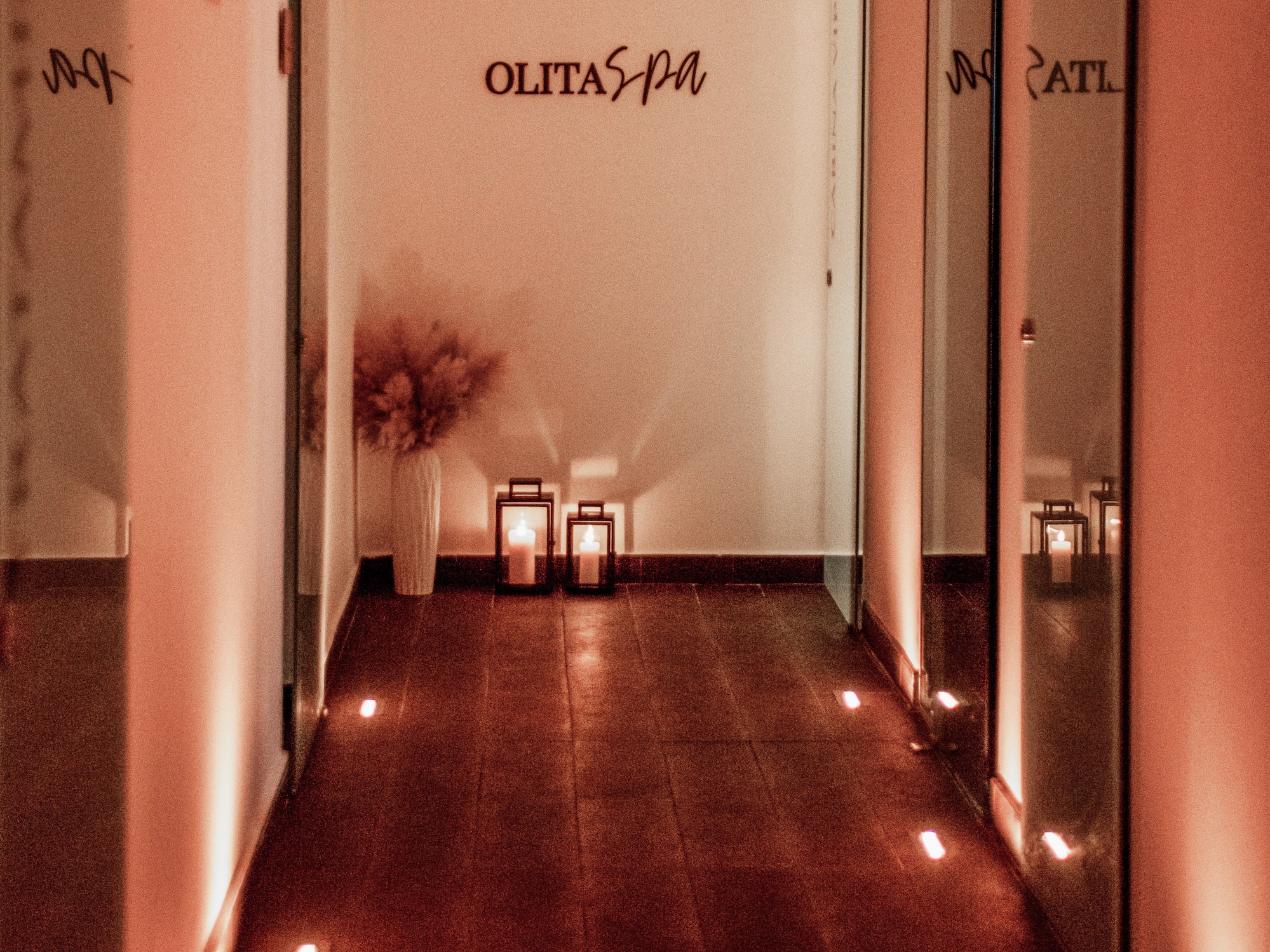 a hallway with lights and a vase on the side.
