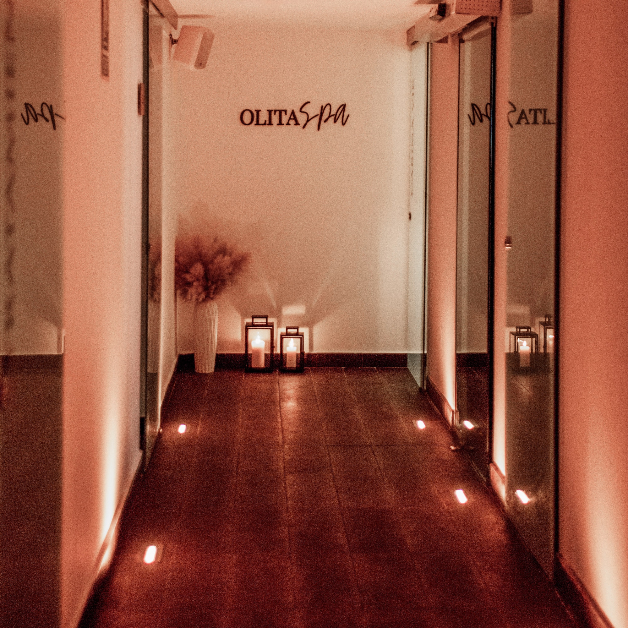 a hallway with lights and a vase on the side