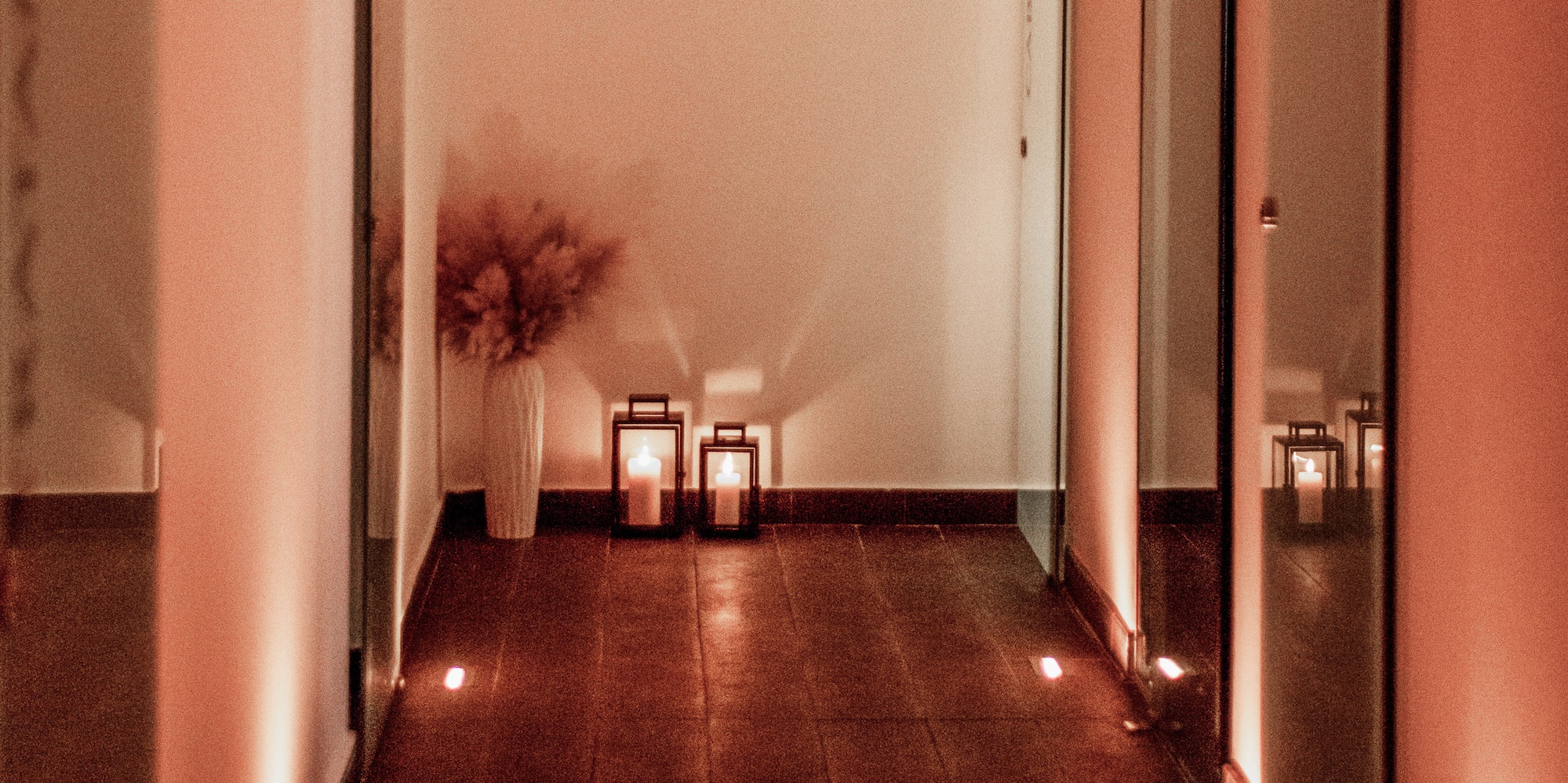 a hallway with lights and a vase on the side