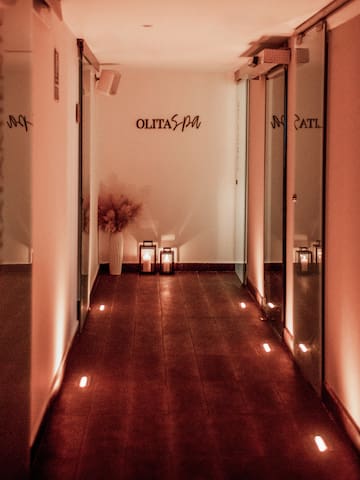 a hallway with lights and a vase on the side.