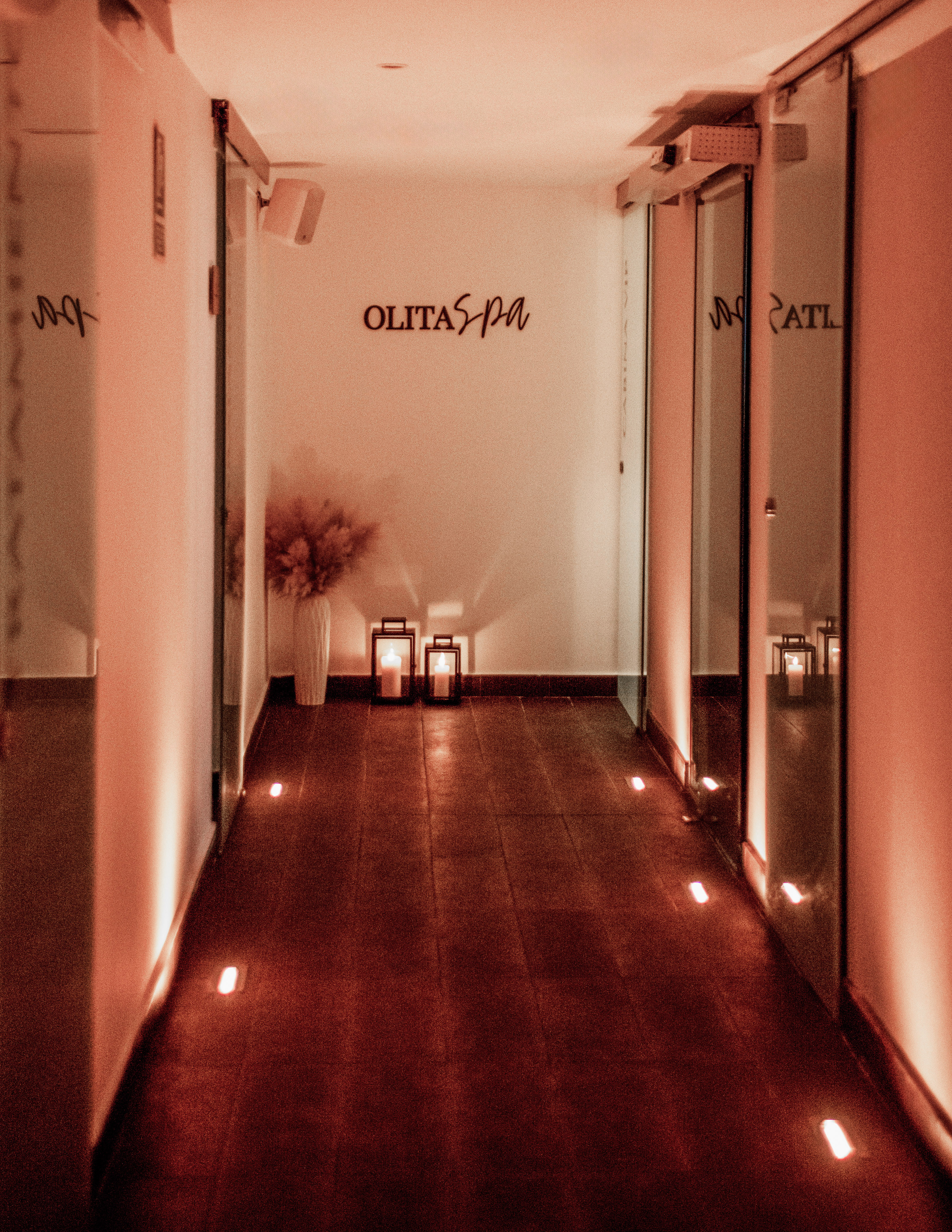 a hallway with lights and a vase on the side