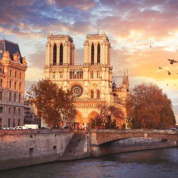 a building with towers and a bridge over a river
