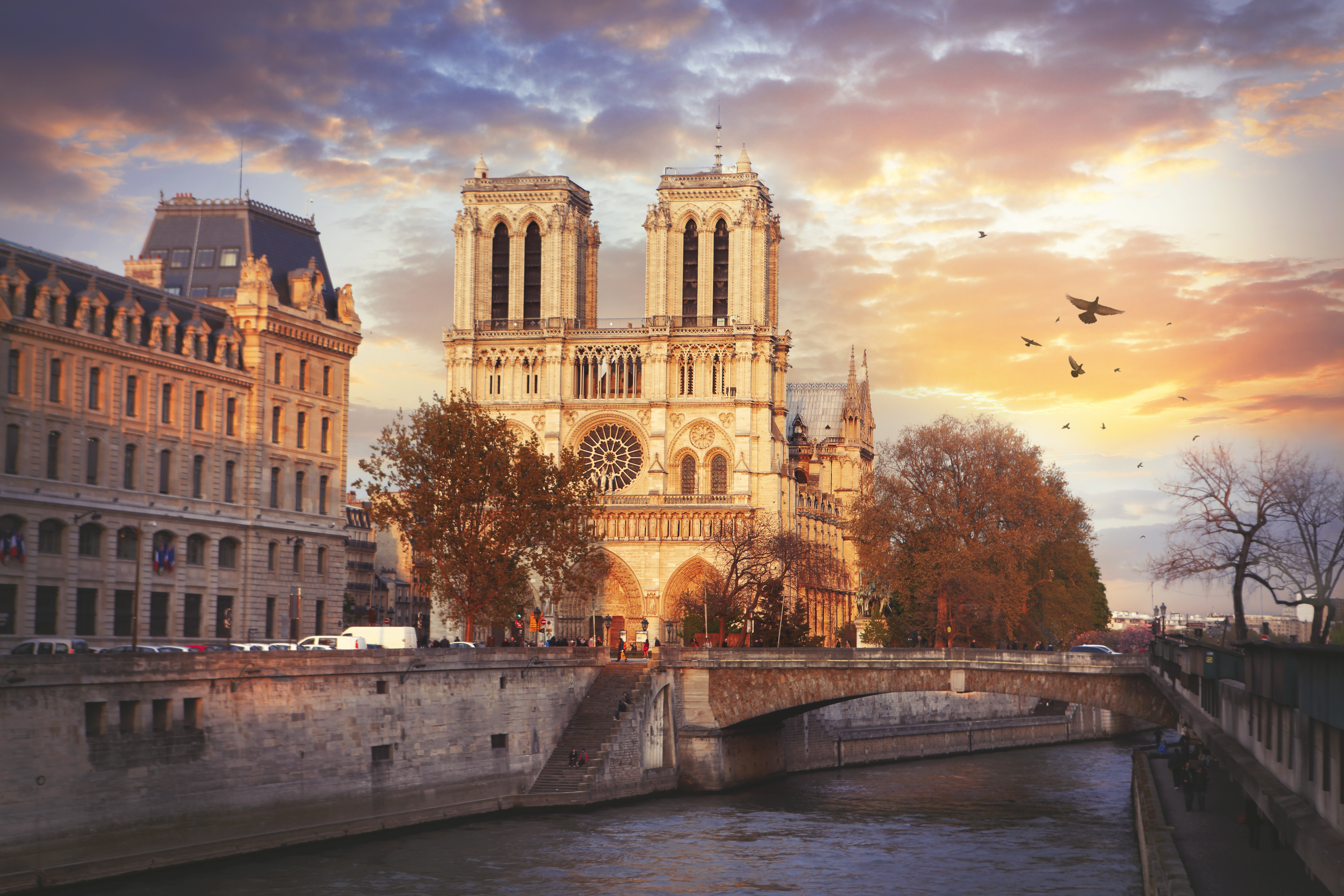 a building with towers and a bridge over a river