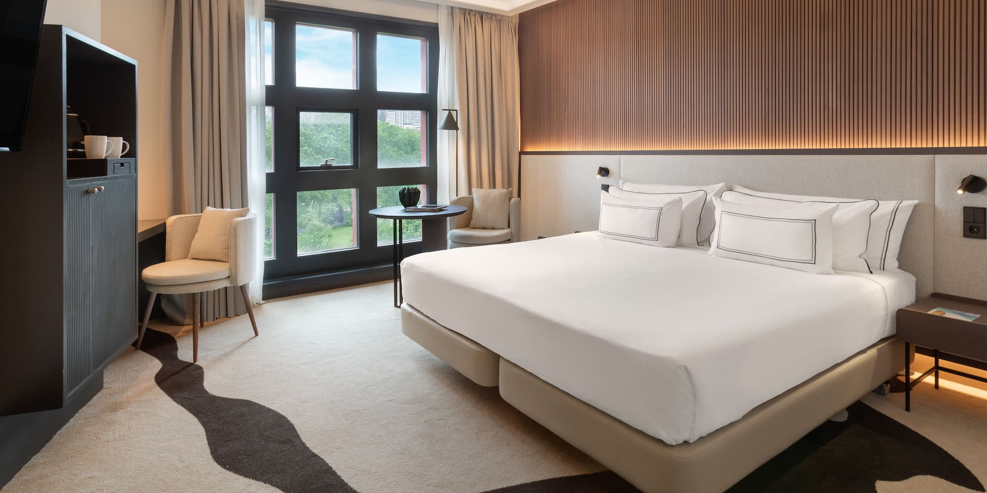 a room with a bed and chairs