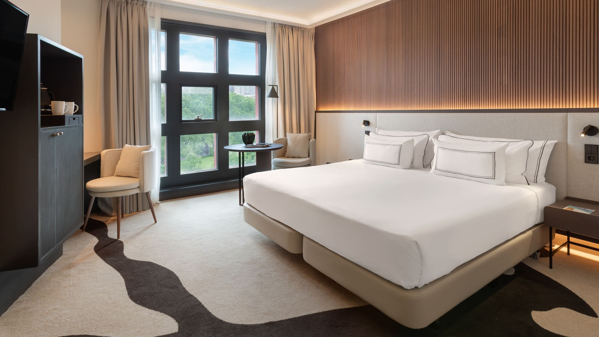 a room with a bed and chairs