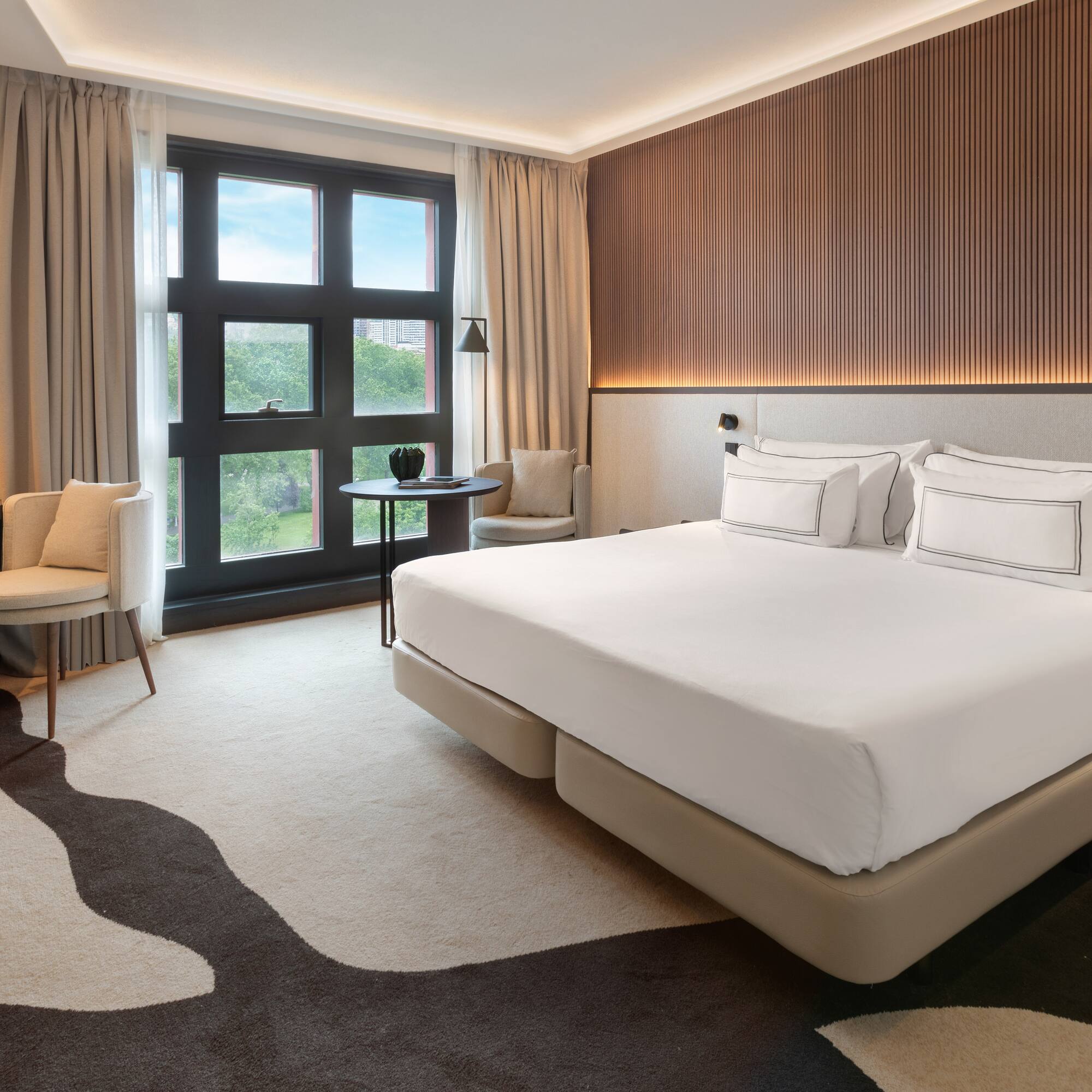 a room with a bed and chairs