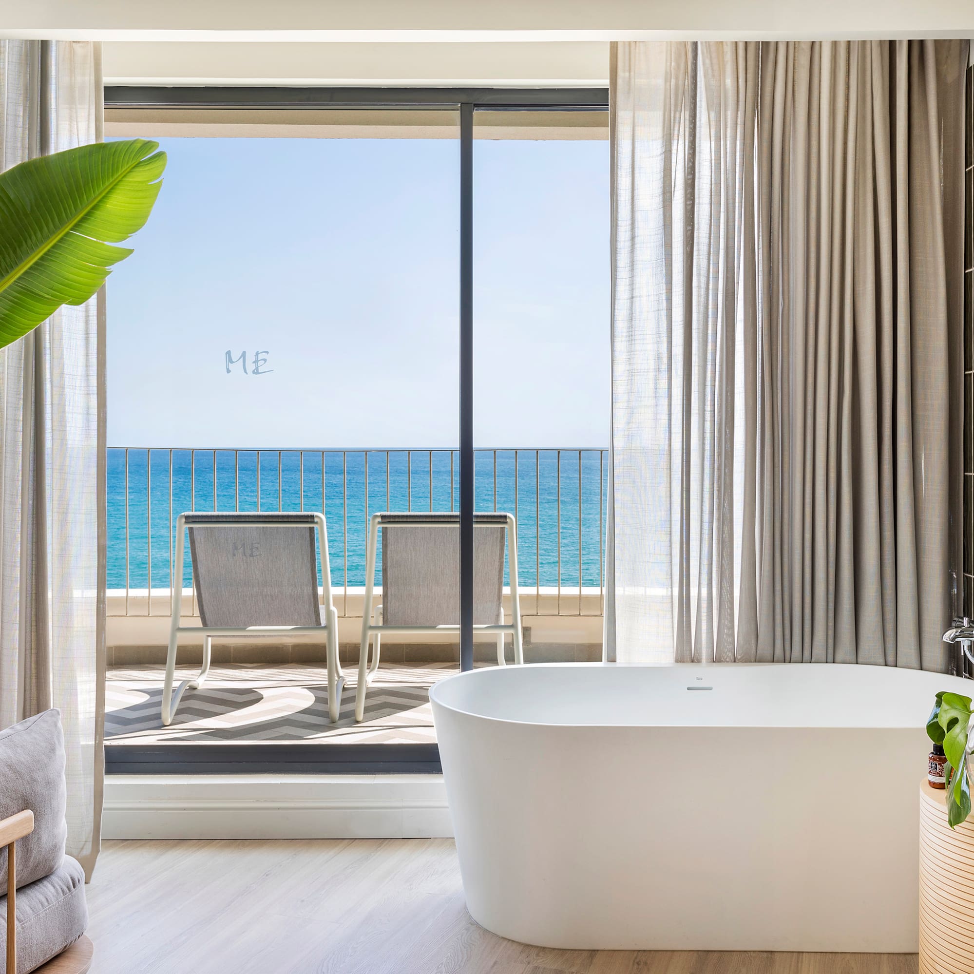 a bathroom with a tub and a large window