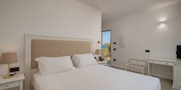 a bed with white sheets and a brown headboard