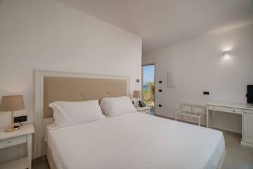 a bed with white sheets and a brown headboard