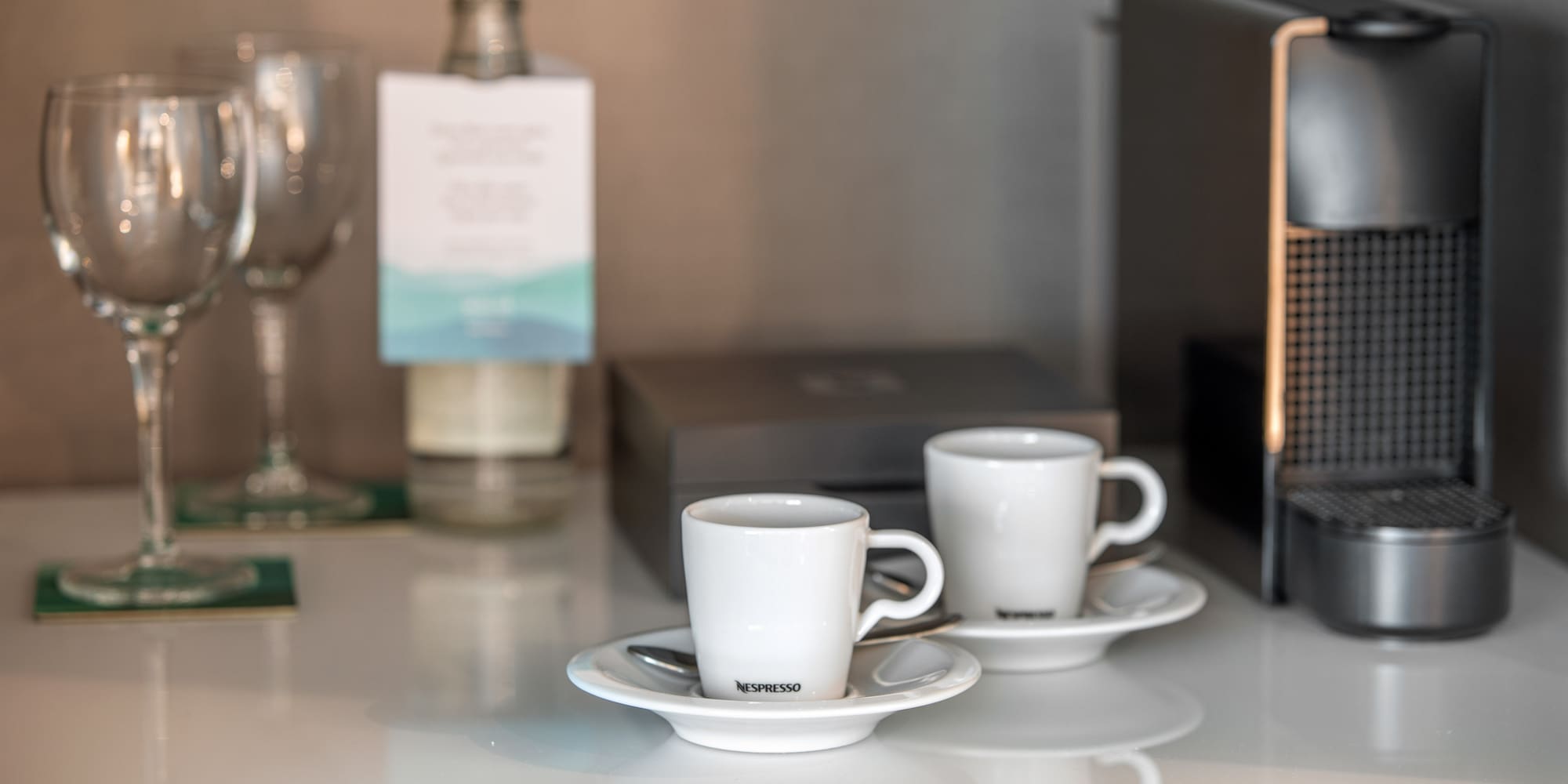 a couple of white cups on saucers on a table